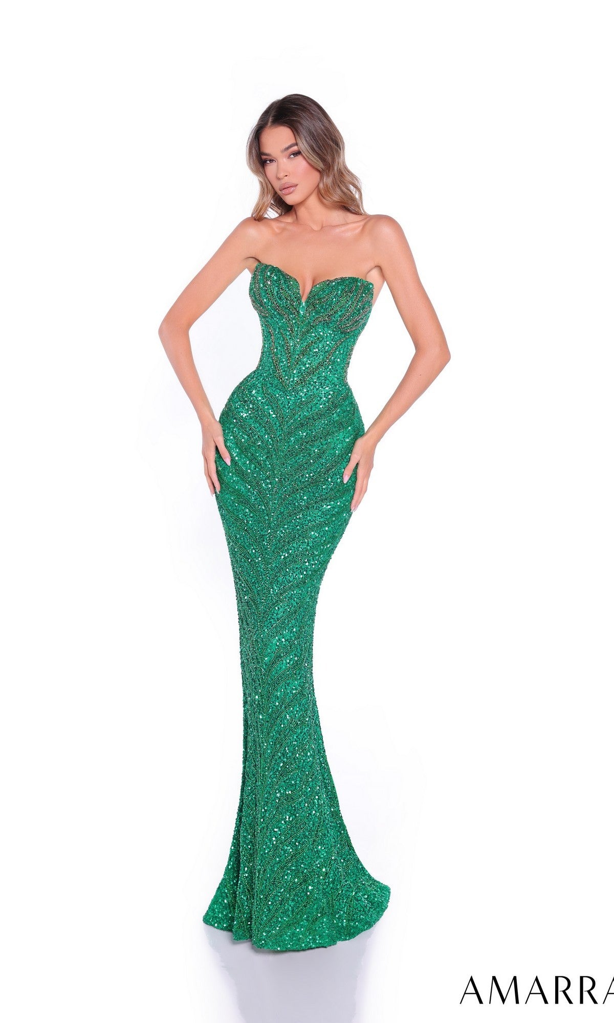 A woman wears the Amarra 89097 long prom dress, a strapless, fitted floor-length green sequin gown with a sweetheart neckline and mermaid silhouette, standing against a plain white background.